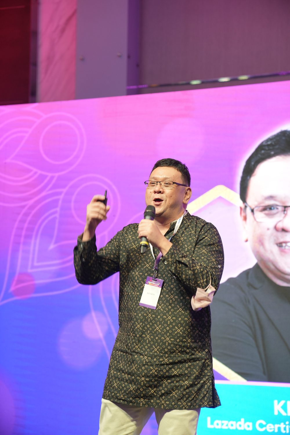 Koh Tak Song with a microphone during a speaking session