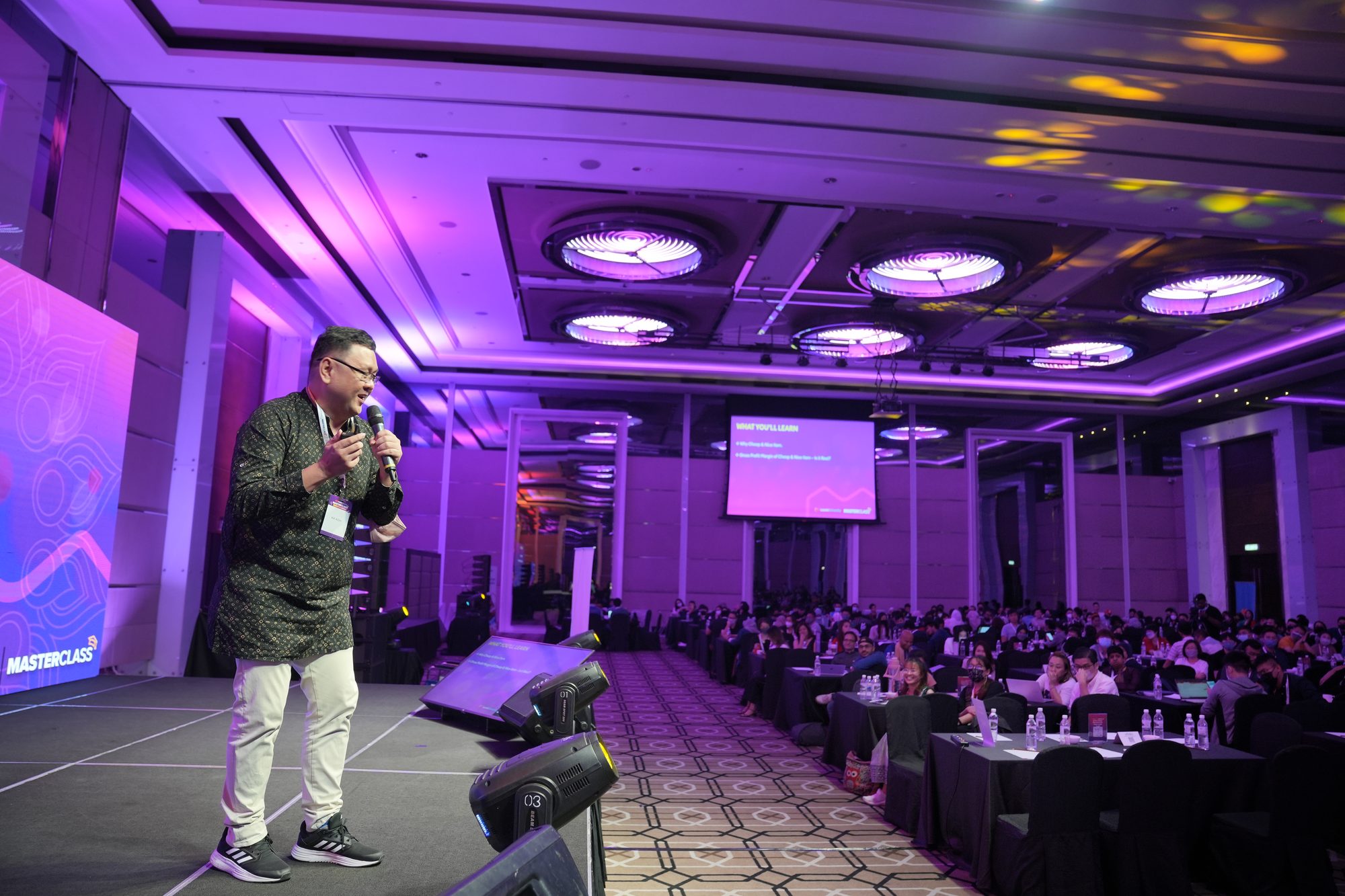 Koh Tak Song speaking on stage to an audience at an e-commerce conference